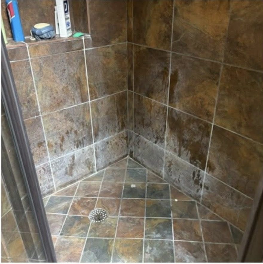 Stone tile shower before cleaning, grime and buildup on tiles