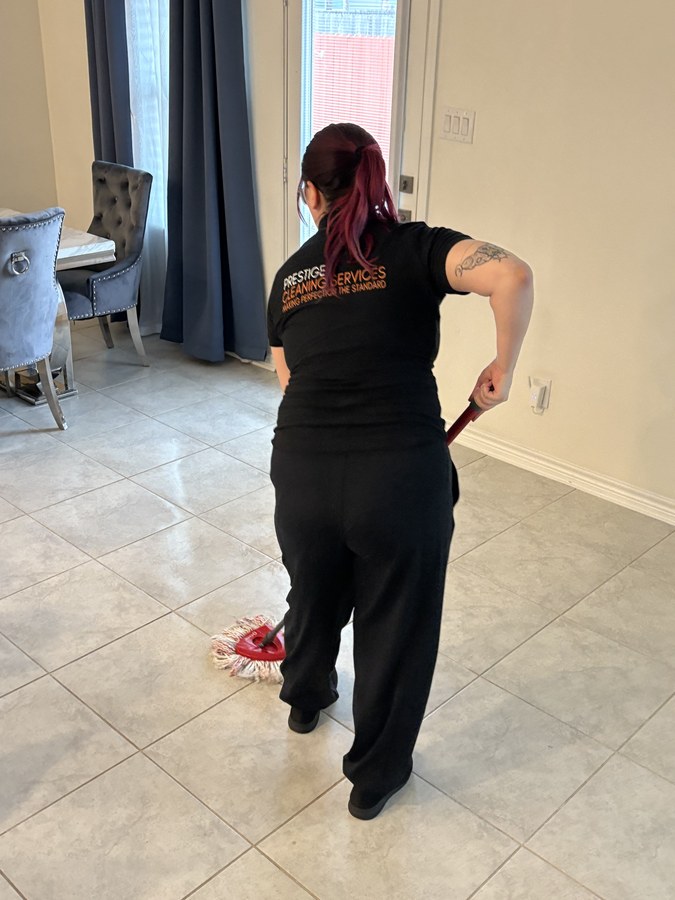 Prestige Cleaning team member mopping tile floor